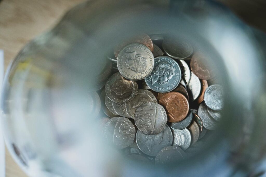 Money inside a change jar for construction project costs contingency pot.